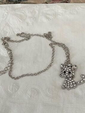 ADORABLE B/W ZIRCONIA KITTEN PENDANT SET IN SILVER, ON A SILVER CHAIN.